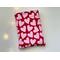 This heart book sleeve has a red background with pink hearts all over it.