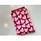 a small book is peeking out of the heart book holder