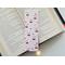 this cherry bookmark has a light pin background with cherries having pink bows on the them, and the smaller ones not having bows on them.