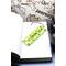 Front of bookmark, lime green background, black handwritten lettering, turtles, starfish and jute rope tassel.