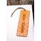 Front of bookmark, orange background, handwritten black lettering, white and black dot art flowers, jute rope tassel.