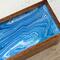 Purple blue with ribbons of white on top of wooden tea caddy.