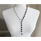 Asymmetrical lariat necklace: one side black coin beads, silver spacers, pewter dangle, other side rhodium chain connected by pewter loop