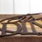 Close up of copper vein powder coat on the oval metal family name sign.