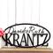 Oval family name metal plaque with first names and last name, in matte black powder coat.