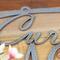 Close up of silver vein powder coat on our personalized family name metal plaque.