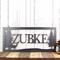 Rectangular metal family name sign, with a doe deer silhouette, in silver vein powder coat.