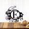 Metal monogram sign with fleur de lis and vines, in matte black powder coat. 