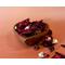 Decorative apple cinnamon potpourri in a heart-shaped wooden bowl, with a soft, ombre styled background in light to dark orange.