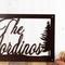 Close up of script lettering and pine trees on our custom family name metal sign, in copper vein powder coat.