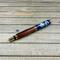 Gold rollerball pen made with wood from Notre Dame stadium bleachers