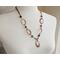Handcrafted copper necklace with hammered washers, faceted petrified wood beads, and a 1" pendant, featuring a rustic boho design.