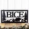 Close up of rectangular metal family name plaque with bear and mountains, in matte black powder coat.