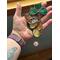 Saint Pat's Bear Suncatchers being held for size reference.