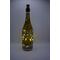 Full view of bottle with dot art designs and darker lighting.