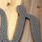 Close up of script lettering on our personalized metal name sign, in silver vein powder coat.