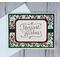 A Christmas card kit with holly scrapbook paper, green cardstock mat, "Merriest Wishes" stamped sentiments and green ribbons.