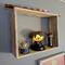 A closeup side-angle of a modern square shelf, handcrafted from natural colored wood. Displayed with a collection of Harry Potter figurines.