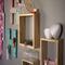 A closeup side-angle of a modern square shelf, handcrafted wood in a natural color. A stylish way to display a collection of 3-D Dragons.