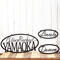 Custom oval metal sign with first and last name, and two child name signs, in matte black powder coat.