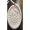 A handcrafted round basket in progress with a crochet hook and scissors nearby, resting on a wooden table with part of a keyboard visible.