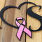 Close up of matte black powder coat with pink vinlyl on the breast cancer ribbon on our survivor metal sign.