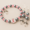 E3
Pink beads with grey pearls and angel charm
