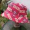 Side view of bucket hat on stand. Fabric has red and gold SF 49ers logos on red background.