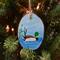A hand-painted mallard wood slice ornament on a Christmas tree.  The ornament is available at Cove Creek Photography.