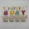 Birthday card with watercolor cupcakes accented with shiny paints on balloon background, candles say happy bday