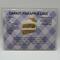 Carrot Pineapple Cake laminated recipe card showing watercolor picture of slice of cake on white and purple plaid background 