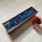 Deep navy is the background for this ocean inspired tea box.  Bubbles of white are accented by metallic gold in the resin.  This mango wood tea organizer can hold up to 50 tea bags for entertaining.