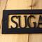 Close up of matte black powder coat on our rectagnular hanging custom cabin name metal plaque.
