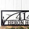 Close up of our custom metal address sign with cattails and a great blue heron, in matte black powder coat.