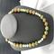 Agate stone with multiple colors. Gold spacers are used between each bead. The necklace is 20 inches long. Included are matching earrings.