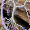 purple jasper adorned roots are attached to a 3 in metal hoop wrapped in lavender color yarn