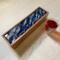 Overview of 5-compartment wooden tea box with ocean waves design.