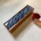 A dark blue background  with ribbons of white an d silver give the impression of movement on top of this wooden tea box.  Perfect for Father's Day or a wedding gift for the tea lover.
