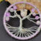 light purple tree displayed against a large chuink of raw crystal