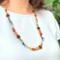 Model wearing fun, colorful, casual beaded necklace with a tropical vibe and made with eco-friendly materials. Adjustable length 24" to 28".