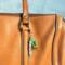 Green fish charm with personalized name hanging from a purse.