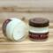 Cool mint and vanilla scented soy candle in 4oz mason jar. One jar standing up with lid on and one jar on its side with lid off.