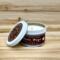 Banana bread scented soy candle in 6oz tin with lid off.