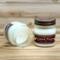Apple cider scented candle in 8oz mason jar. One jar standing up with lid on and one jar on its side with lid off.