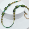An 18-inch handmade necklace with vintage olive-green glass beads, bicones, and seed beads on a gold-plated stainless steel chain