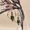 A pair of handmade 2-inch earrings with olive green vintage glass beads, green glass bicones and gold spacers with gold-plated circle frame