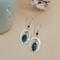 Dangle earrings with sodalite marquise stones and hand-hammered pewter ovals on Argentium silver ear wires.