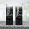 Black and silver glitter bride and groom tumblers with lids and straws shown together
