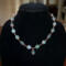 Moss agate beads in shades of teal, green and blue are linked by wire wrapping to form a necklace with copper clasp. 