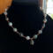 Moss agate beads in shades of teal, green and blue are linked by wire wrapping to form a necklace with copper clasp. 